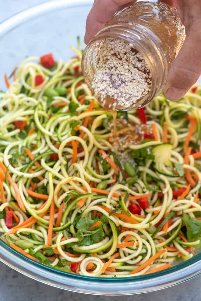 The Ginger Sesame-Soy Dressing being poured over the top of the salad.