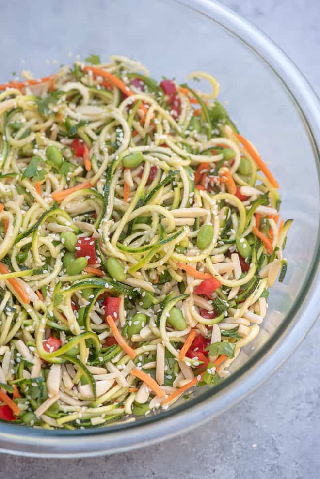 A large glass bowl filled with Asian Zucchini Noodle Salad.