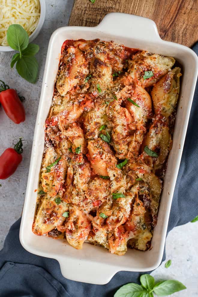 An overhead shot of chicken parmesan stuffed shells in a baking dish