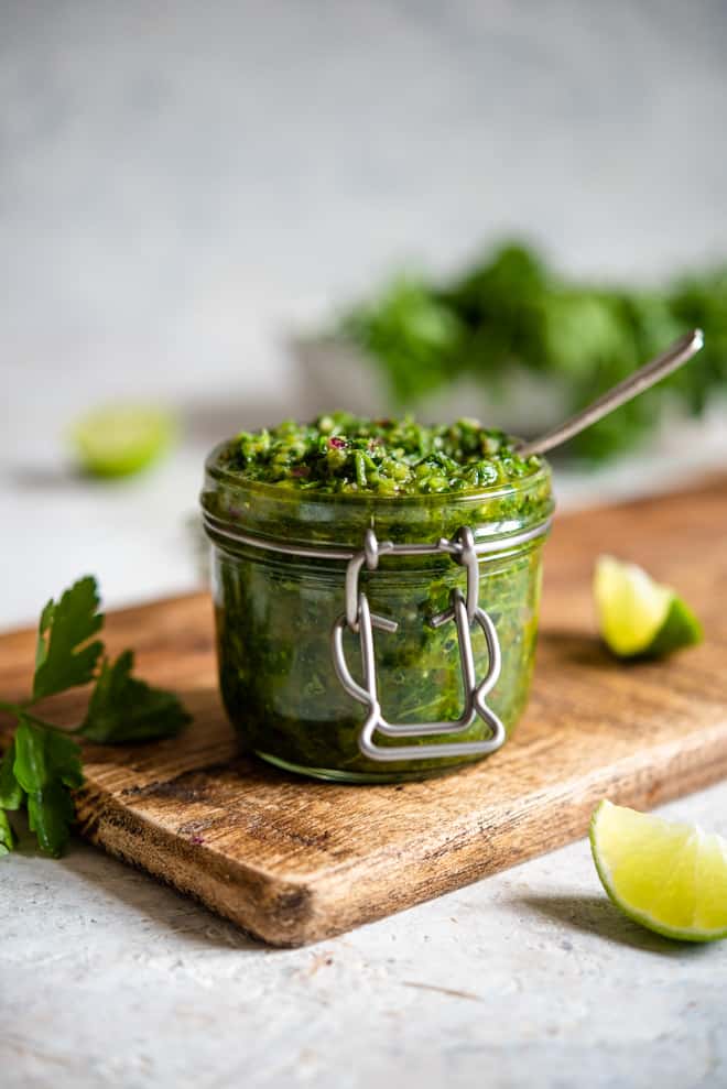 Cilantro chimichurri in a glass jar with a spoon