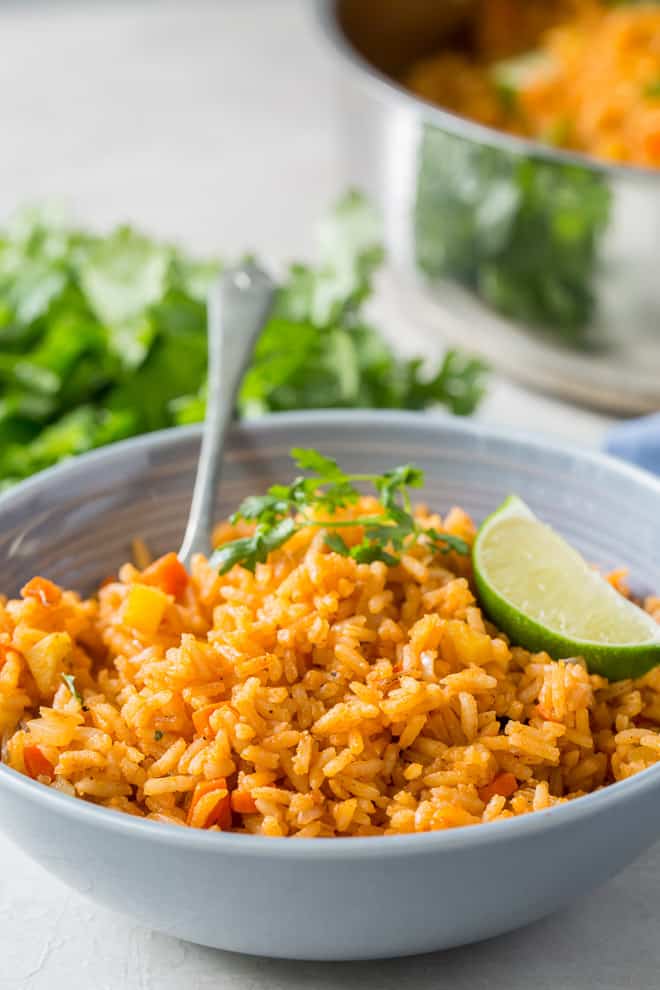 A serving of Restaurant Style Mexican Rice in a serving bowl with a fork.