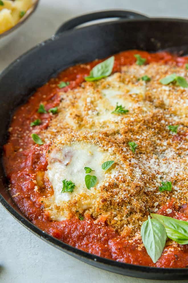 A close up image of Skillet Chicken Parmesan in a cast iron skillet.