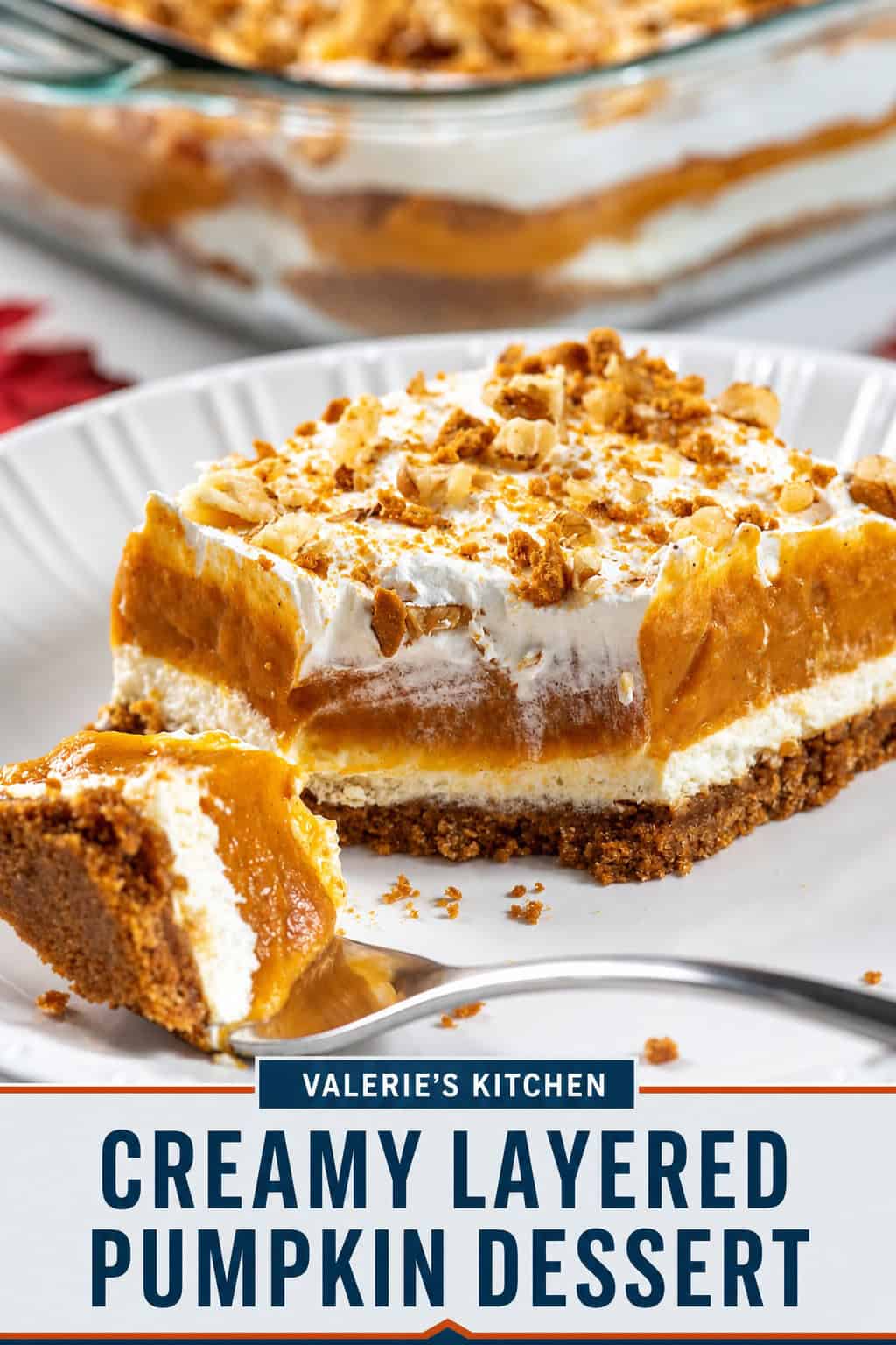 A slice of creamy layered pumpkin dessert with gingersnap crust, cream cheese and pumpkin layers, whipped topping, and crushed gingersnaps and walnuts. Text overlay reads “Creamy Layered Pumpkin Dessert.”