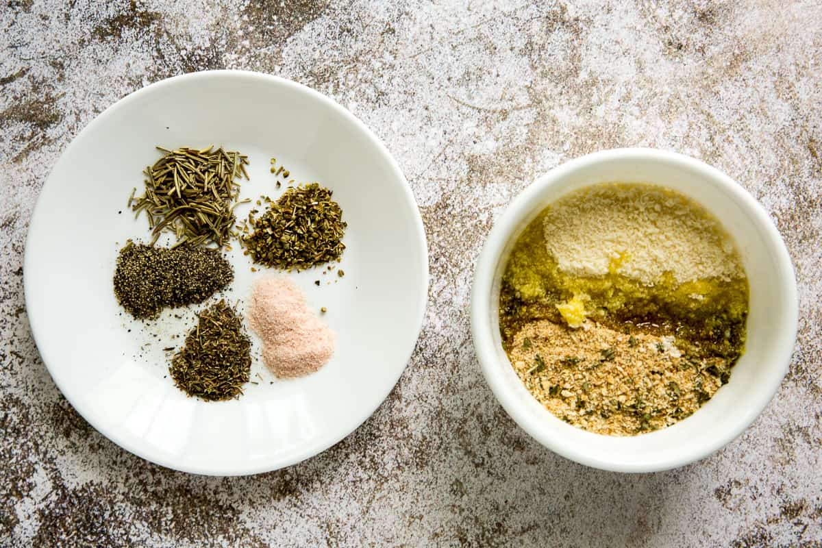 Two white bowls with spices and a breadcrumb mixture.