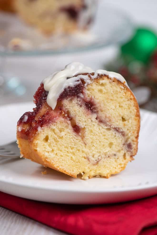 A slice of Cranberry Swirl Bundt Cake on a small white serving plate.