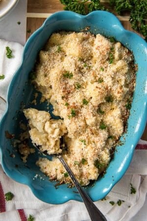 A cauliflower casserole in a blue dish topped with bread crumbs.