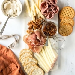 A tray with crackers, cheese, and bacon jam.