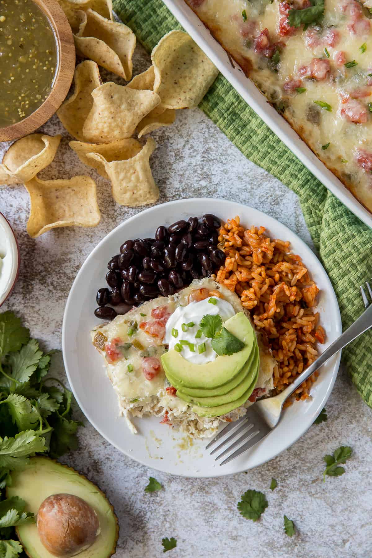 Chicken Tortilla Casserole on a plate with black beans and rice.