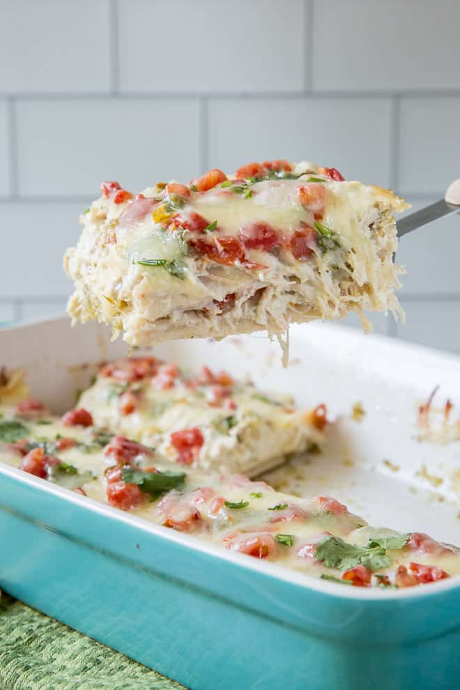 A spatula lifting a slice of Chicken Tortilla Casserole from the casserole dish. This recipe uses pantry staples you can easily stock.