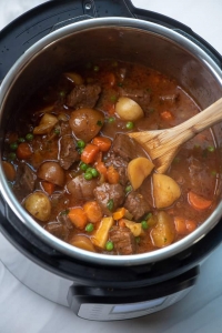 A wooden spoon in an Instant Pot full of Beef Stew.