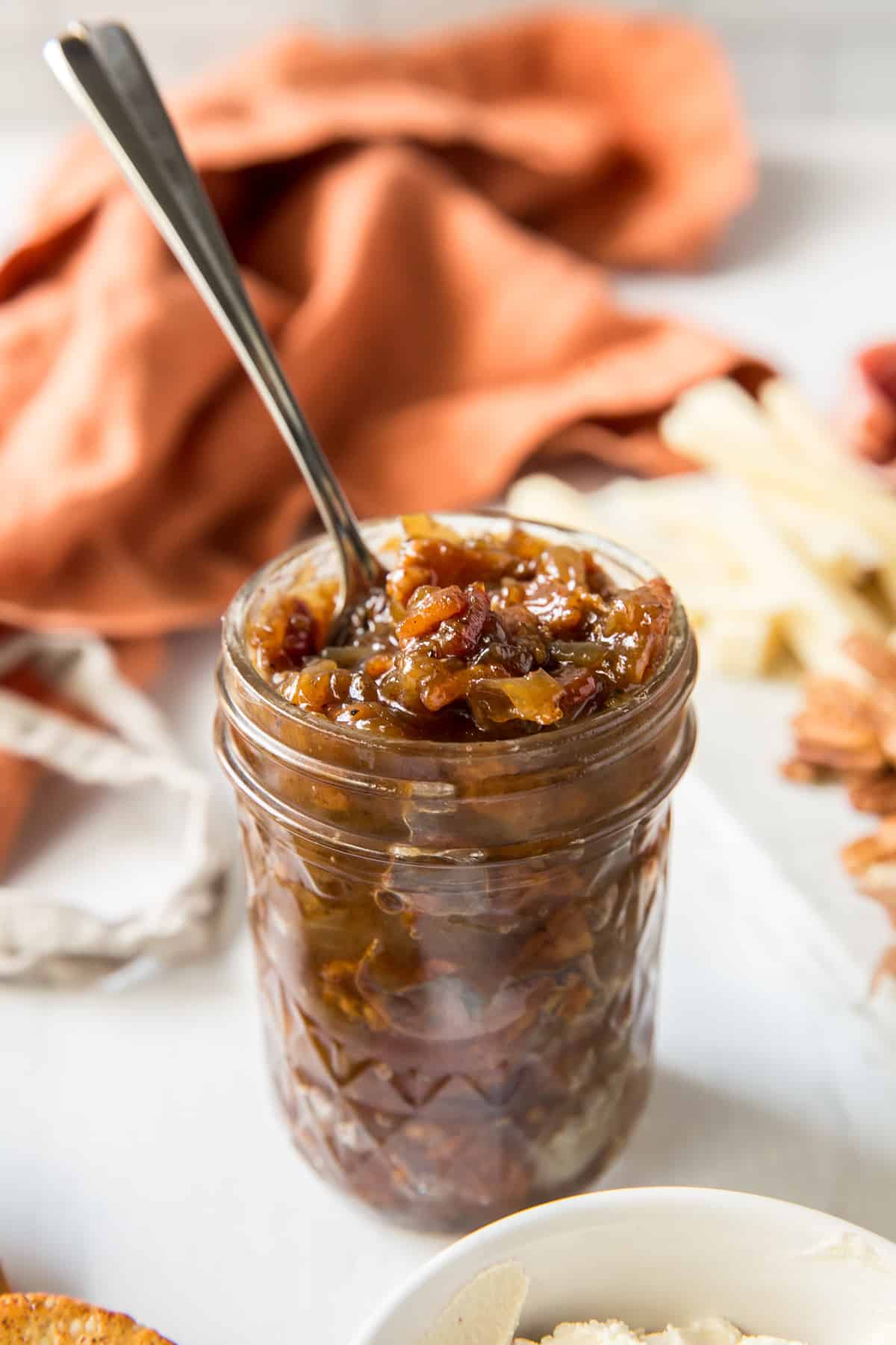 A spoon resting in a jar of bacon jam.