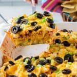 A spatula lifts a piece of casserole from a baking dish.