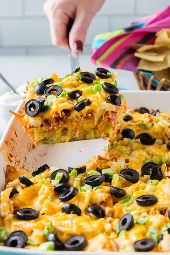 A spatula lifting a serving of Chicken Tamale Casserole from the casserole dish. Easy pantry staple recipes.