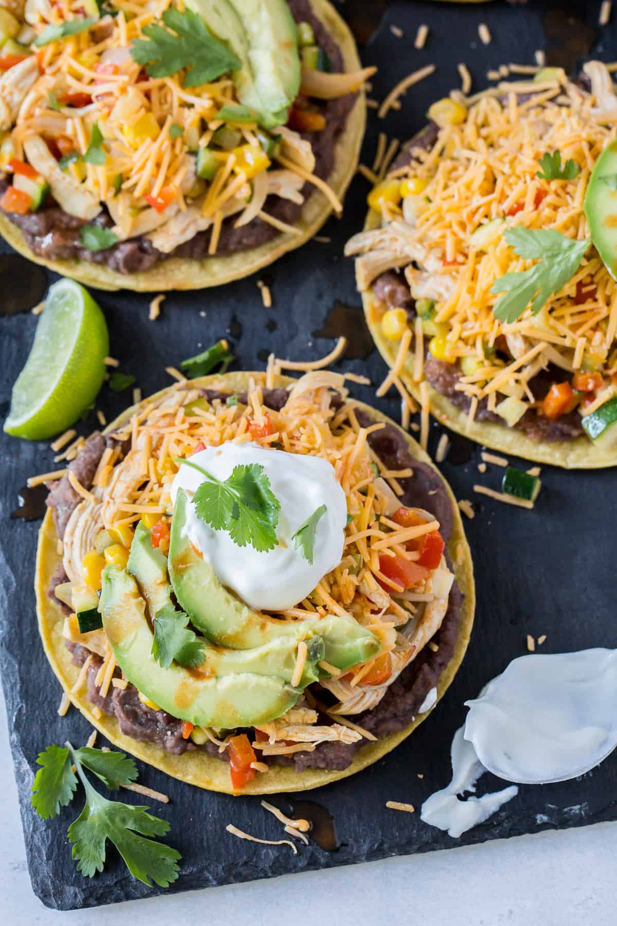 Tostadas topped with cheese, sour cream and avocado.