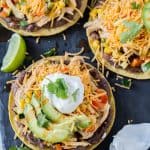 Tostadas topped with cheese, sour cream and avocado.