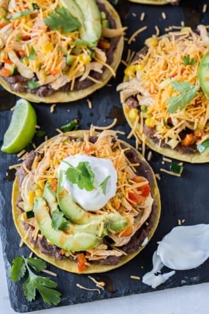 Tostadas topped with cheese, sour cream and avocado.