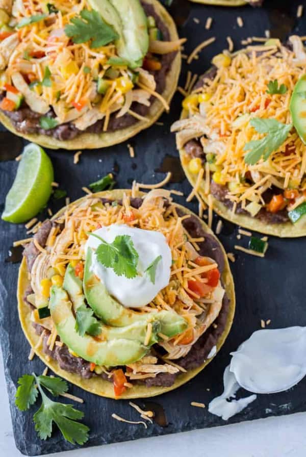 Tostadas topped with cheese, sour cream and avocado.