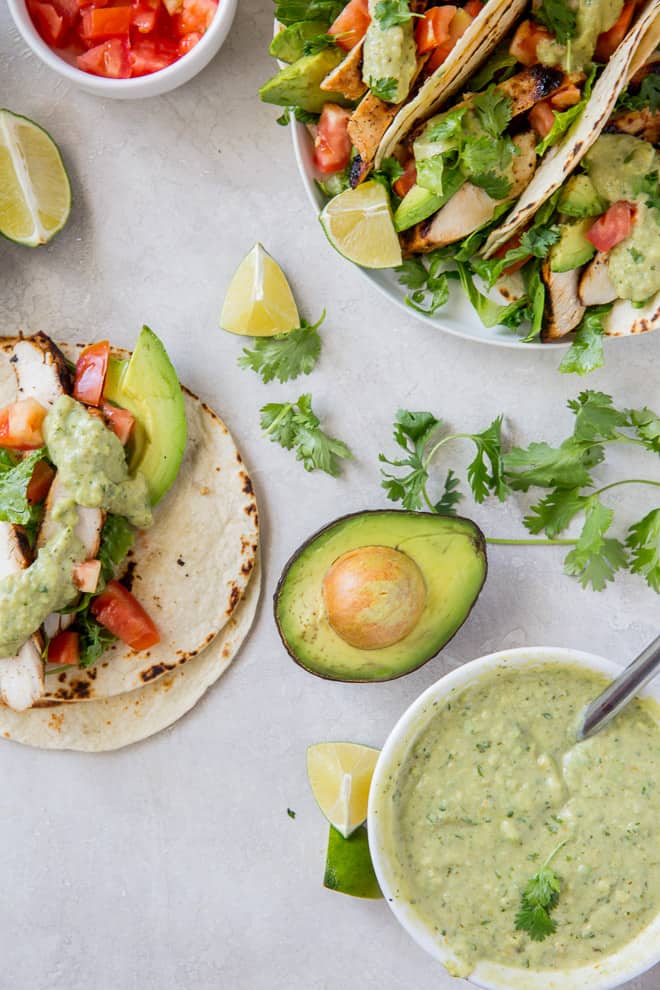 Grilled chicken tacos topped with Creamy Avocado Tomatillo Salsa , chopped tomatoes and cilantro.