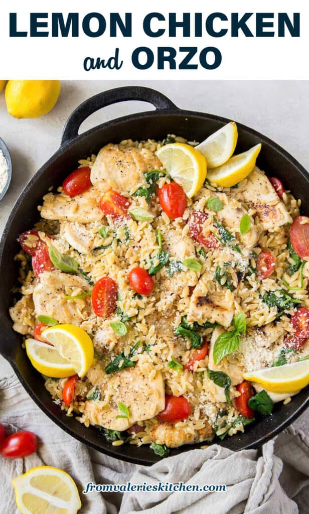 A skillet filled with orzo, chicken, grape tomatoes, and slices of lemon with text.