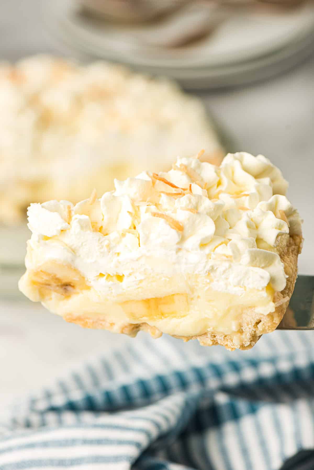 A spatula lifts a slice of Old Fashioned Banana Cream Pie.