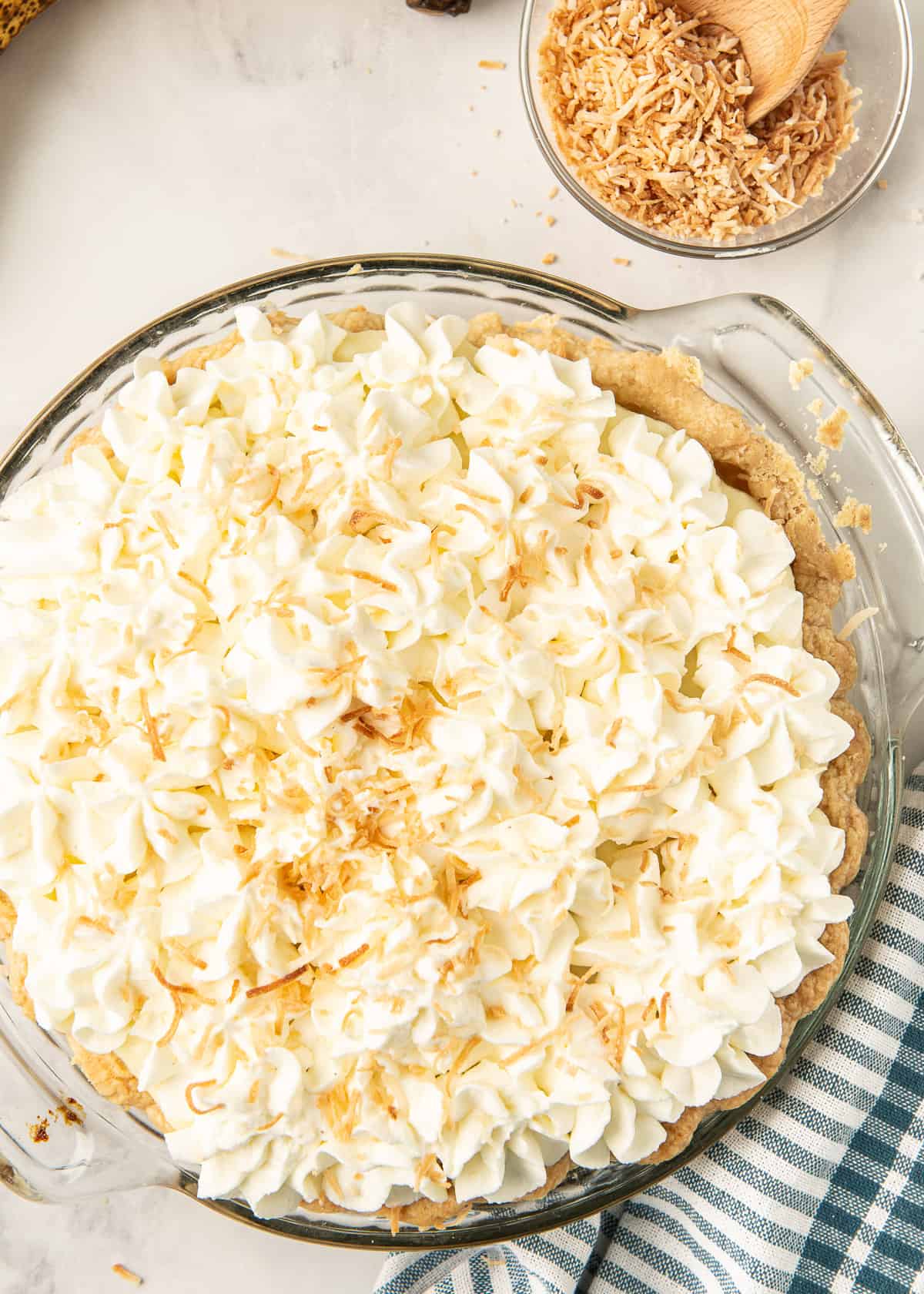 Banana Cream Pie in a pie dish topped with toasted coconut.