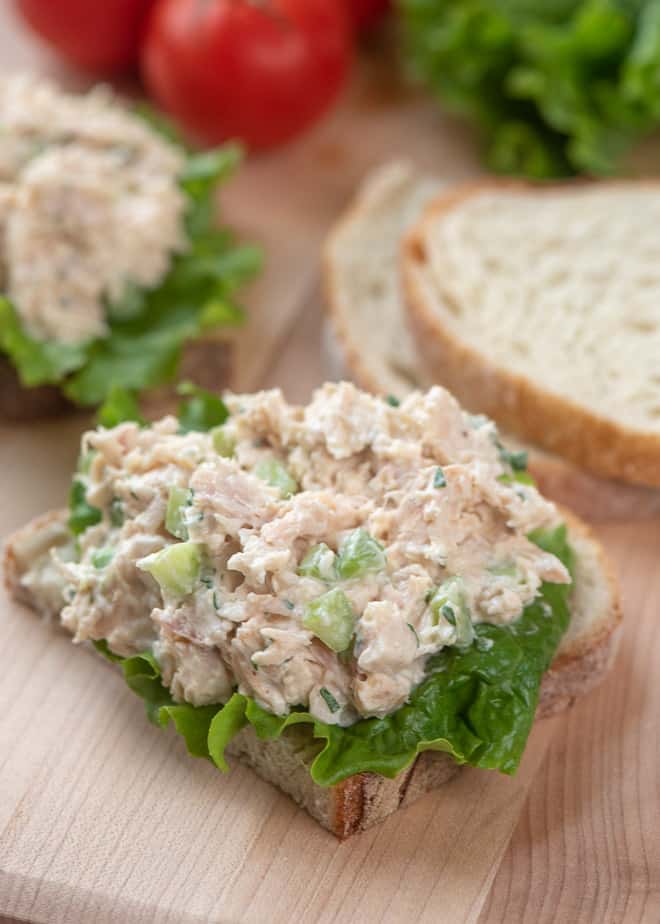 An open face Chicken Salad Sandwich on a cutting board.