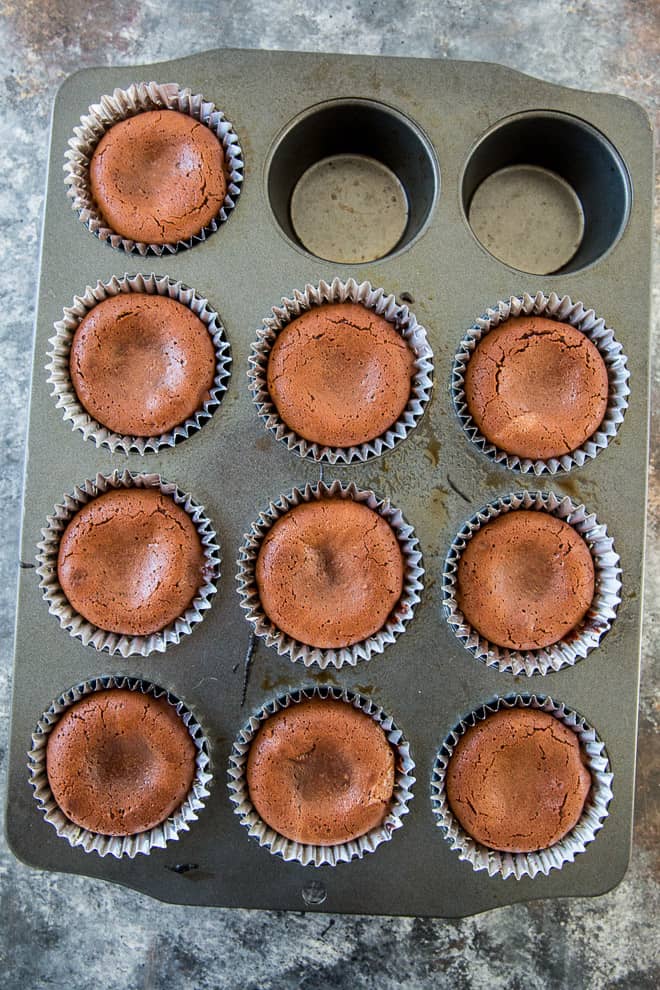 A muffin pan with 10 baked Molten Chocolate Cakes shot from overhead.