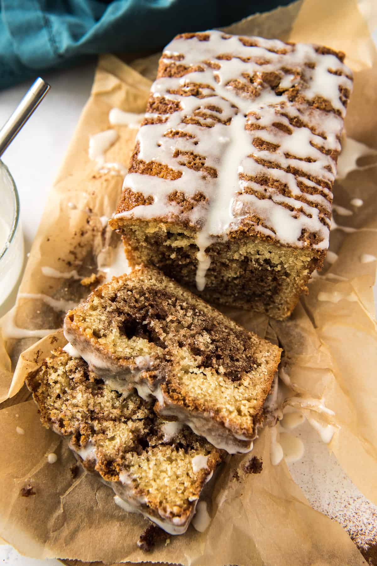 A sliced loaf of Cinnamon Swirl Quick Bread on a sheet of parchment paper.