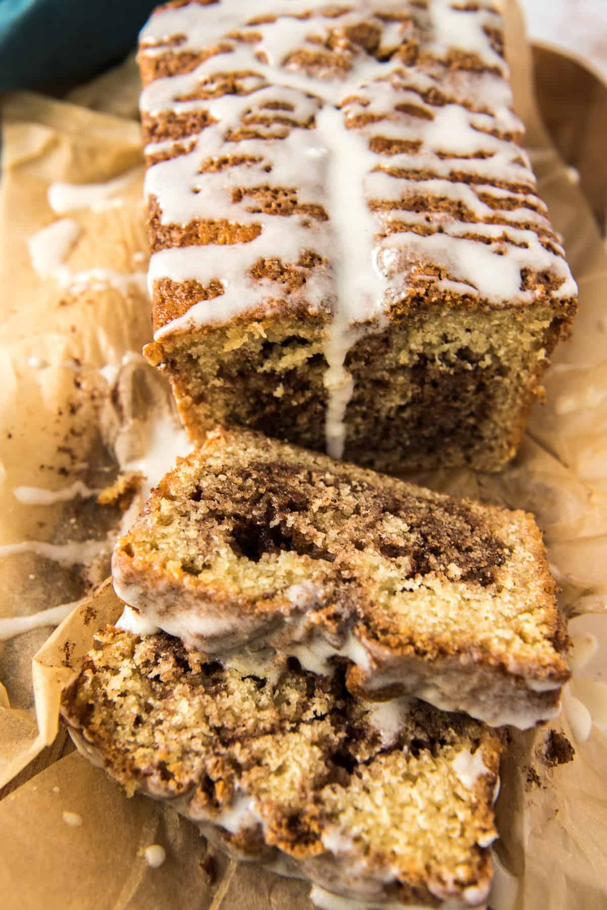 A sliced loaf of Cinnamon Swirl Bread with icing.