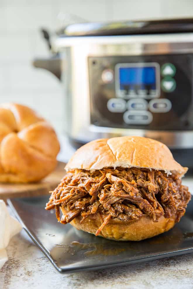 A Barbecue Beef Sandwich with a slow cooker in the background.