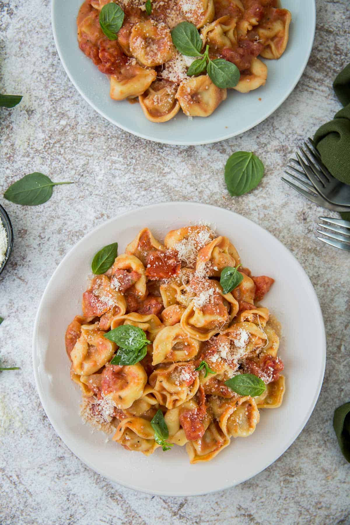 Two bowls of tortellini with tomato cream sauce.