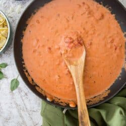 Tomato Cream Sauce in a skillet with a wooden spoon.