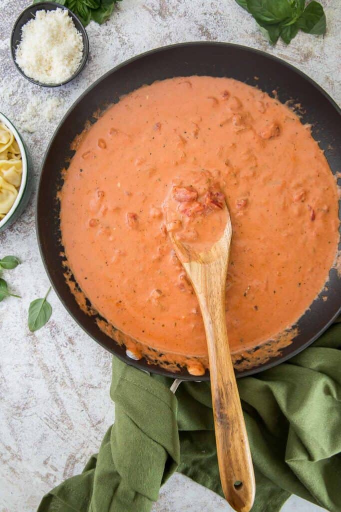 Tomato Cream Sauce in a skillet with a wooden spoon.