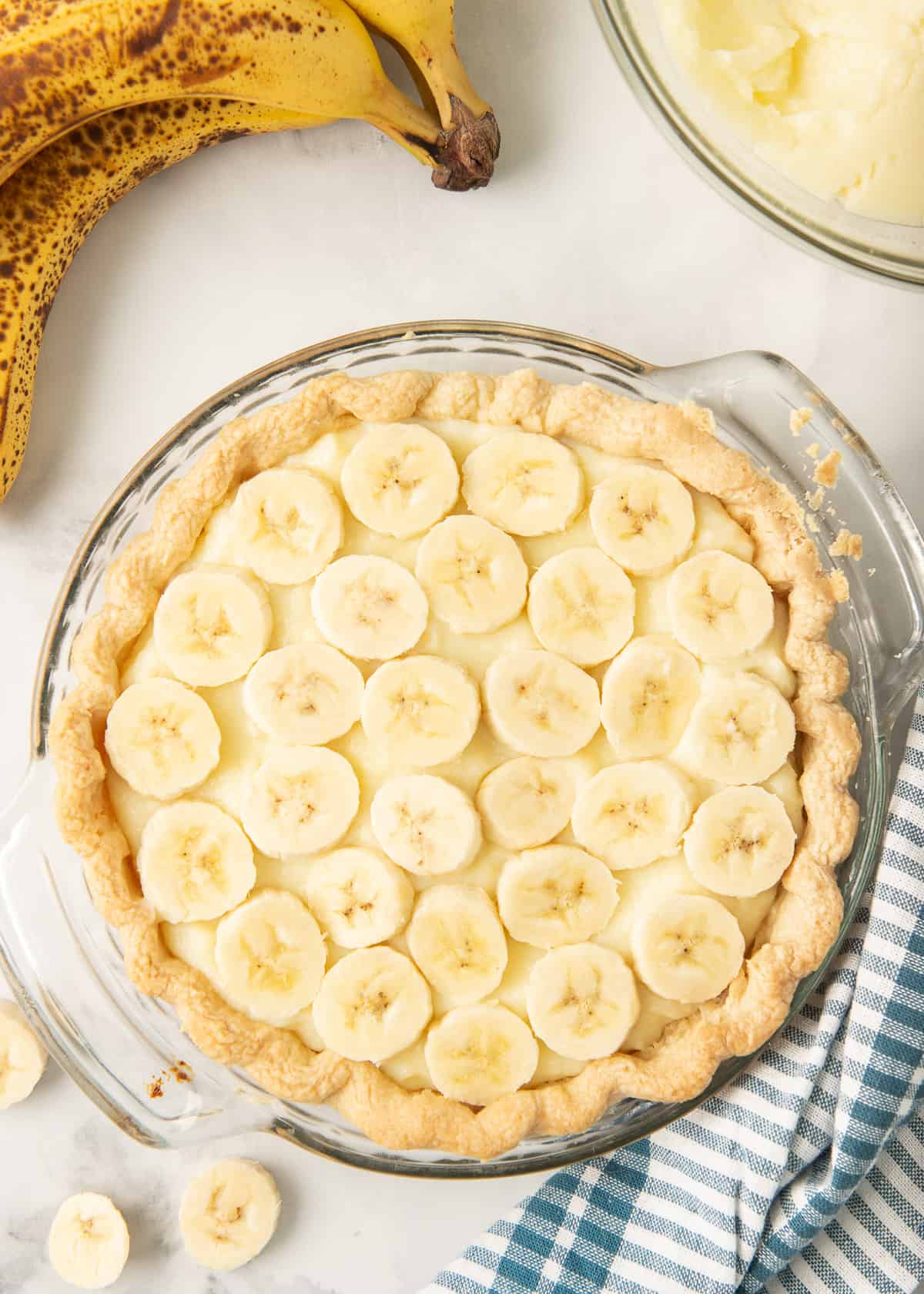 Sliced bananas are placed on top of the custard layer.