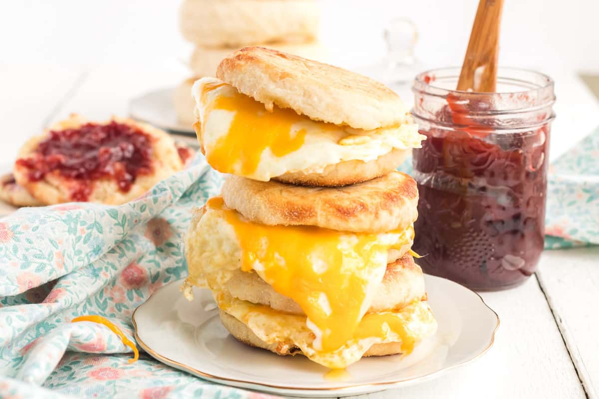A stack of breakfast sandwiches on English muffins.