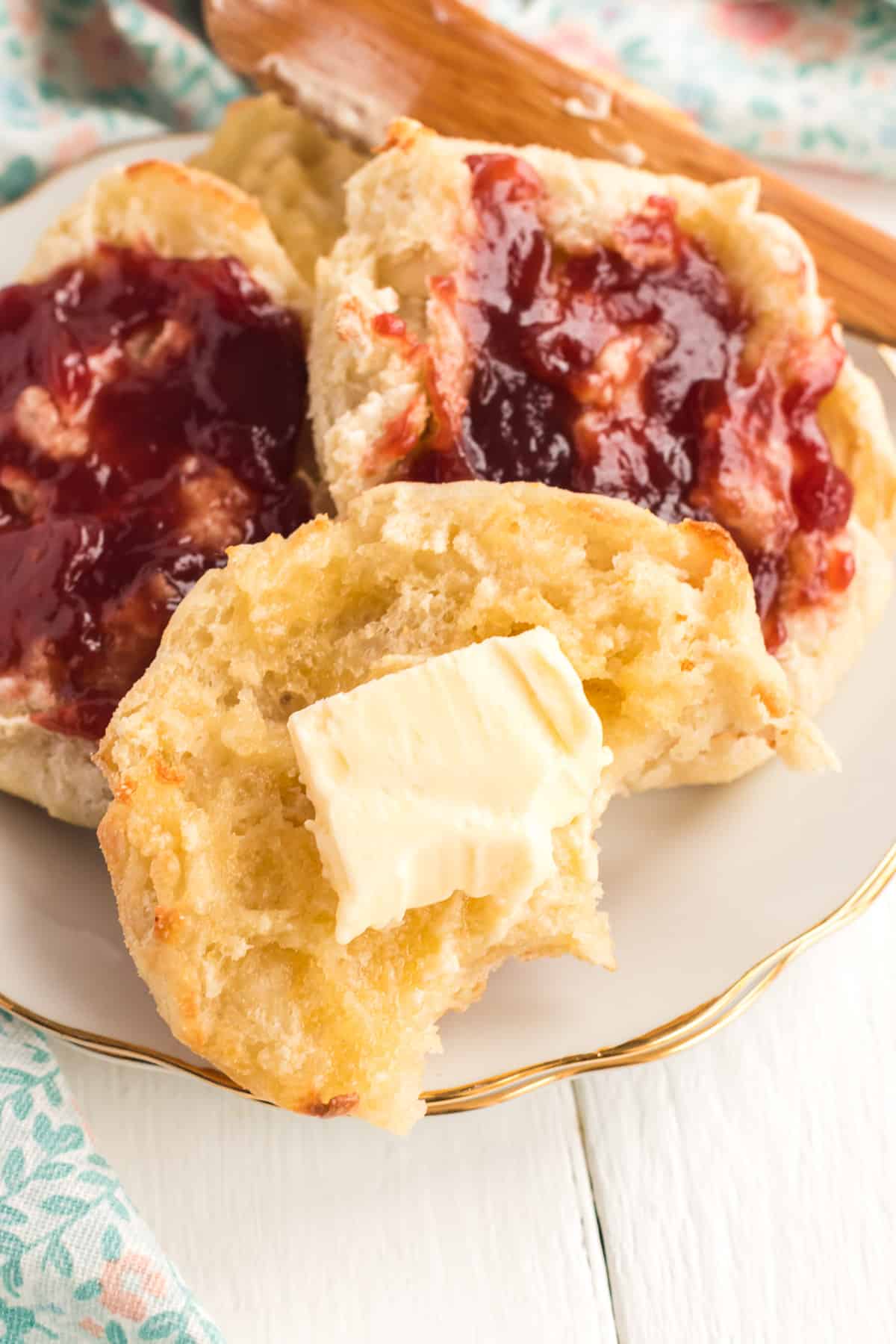 English muffins with jelly with a bite taken out of the one in the foreground.