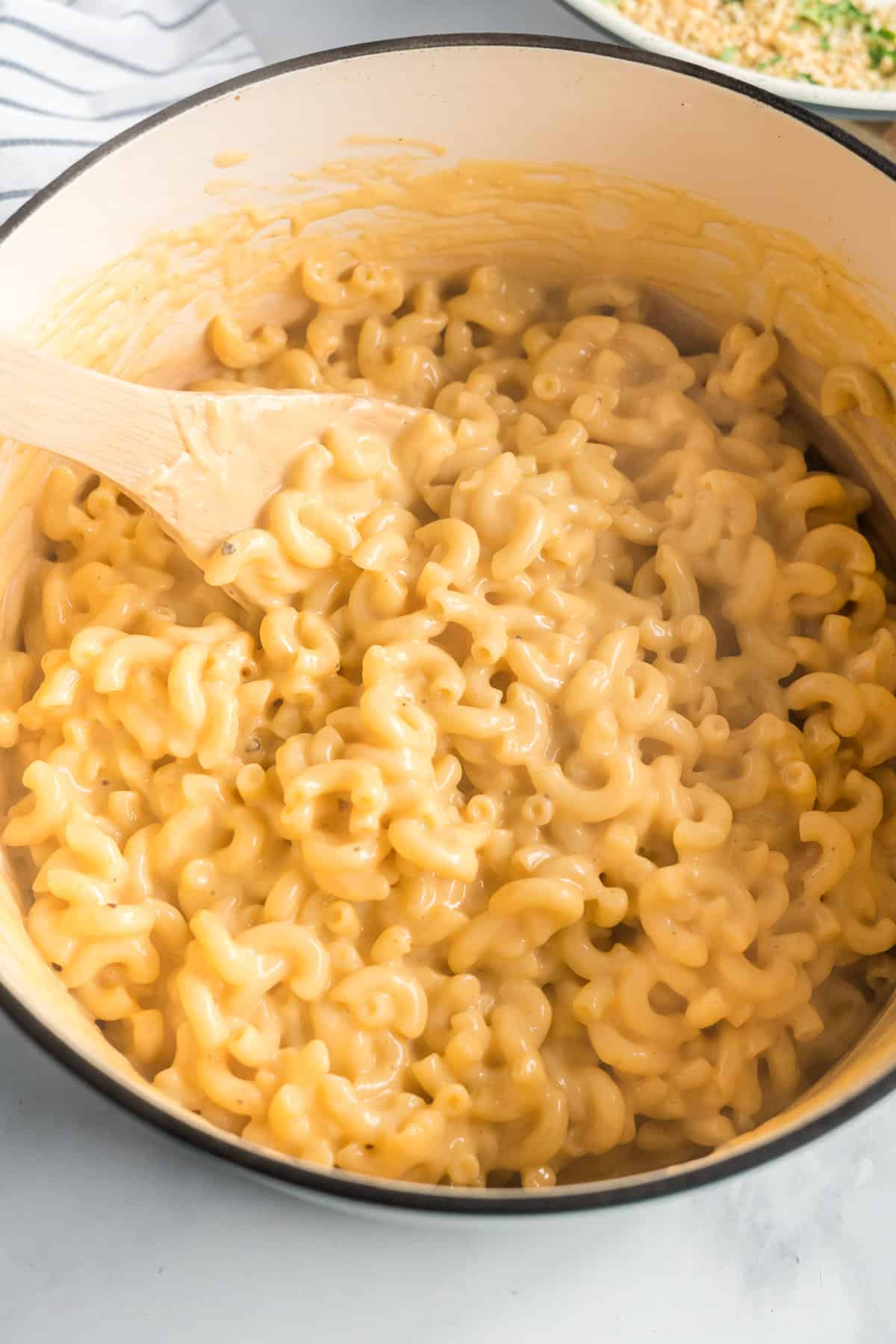 The creamy pasta and cheese mixture after it is combined in the Dutch oven.