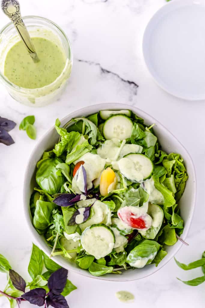 A green salad dressed with Basil Buttermilk Dressing shot from the top.