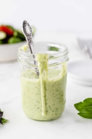 Basil Buttermilk Dressing in a mason jar with a spoon.