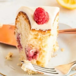 A slice of Lemon Raspberry Bundt Cake on a white place with a fork.