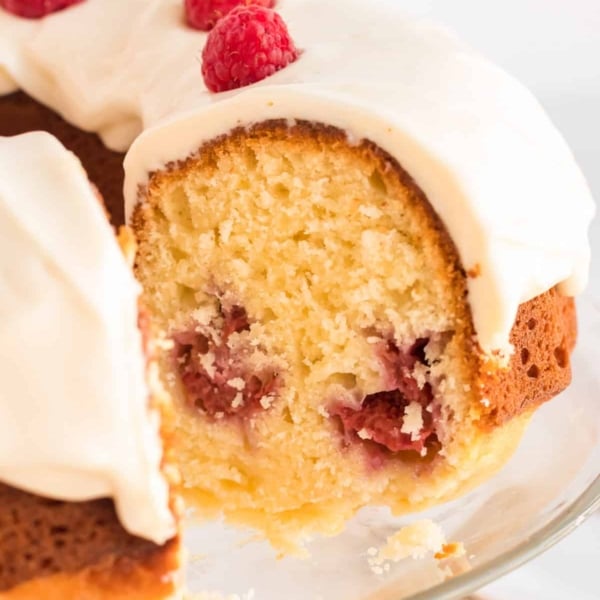 A side view of the Lemon Raspberry Bundt Cake with a slice missing revealing the center.