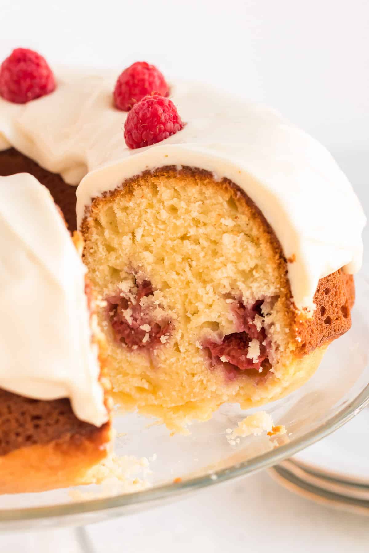 A side view of the Lemon Raspberry Bundt Cake with a slice missing revealing the center.