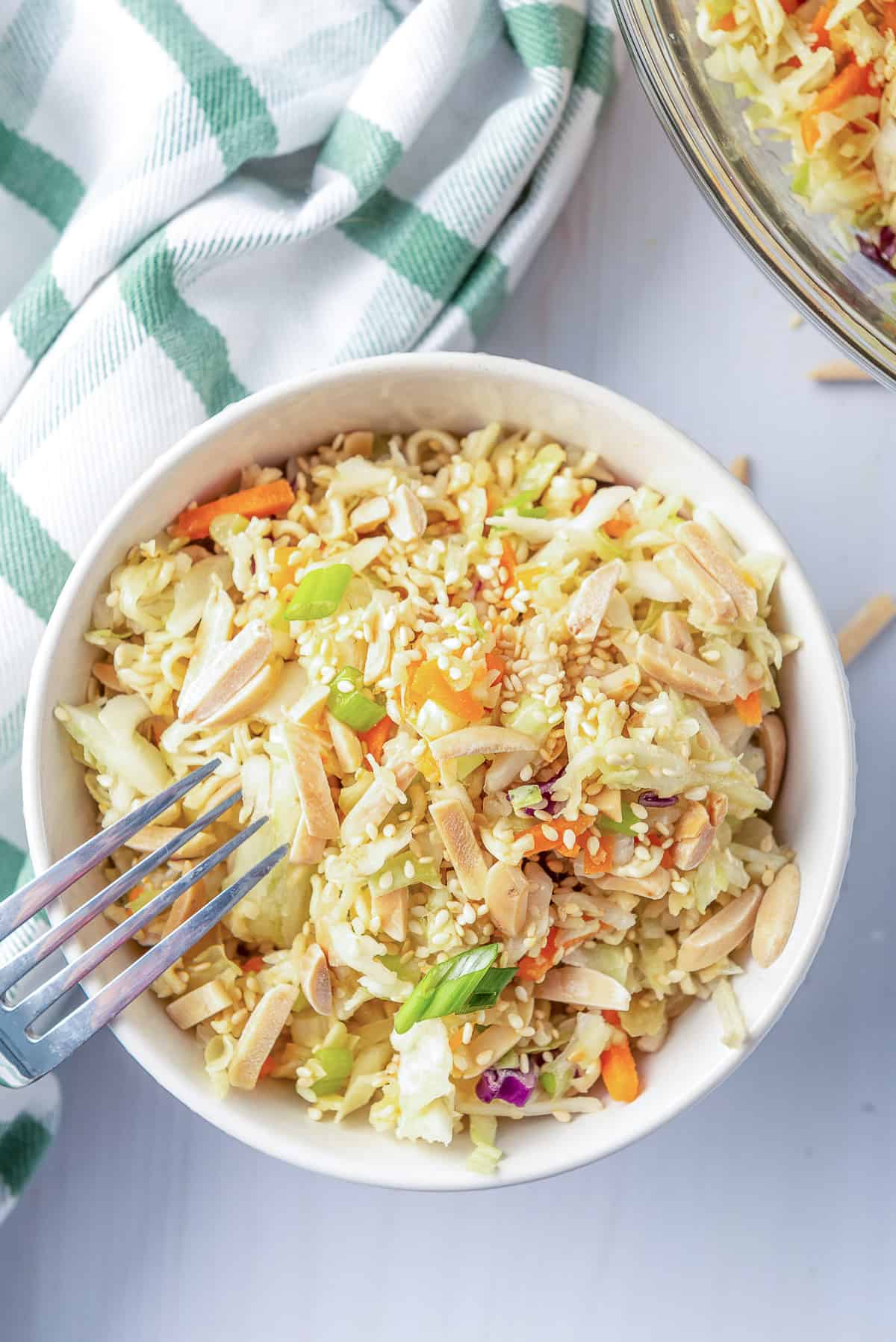 Ramen Cabbage Salad in a white bowl with a fork shot from over the top.