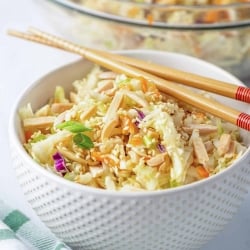 A white bowl filled with Ramen Cabbage Salad with chopsticks lying over the top.