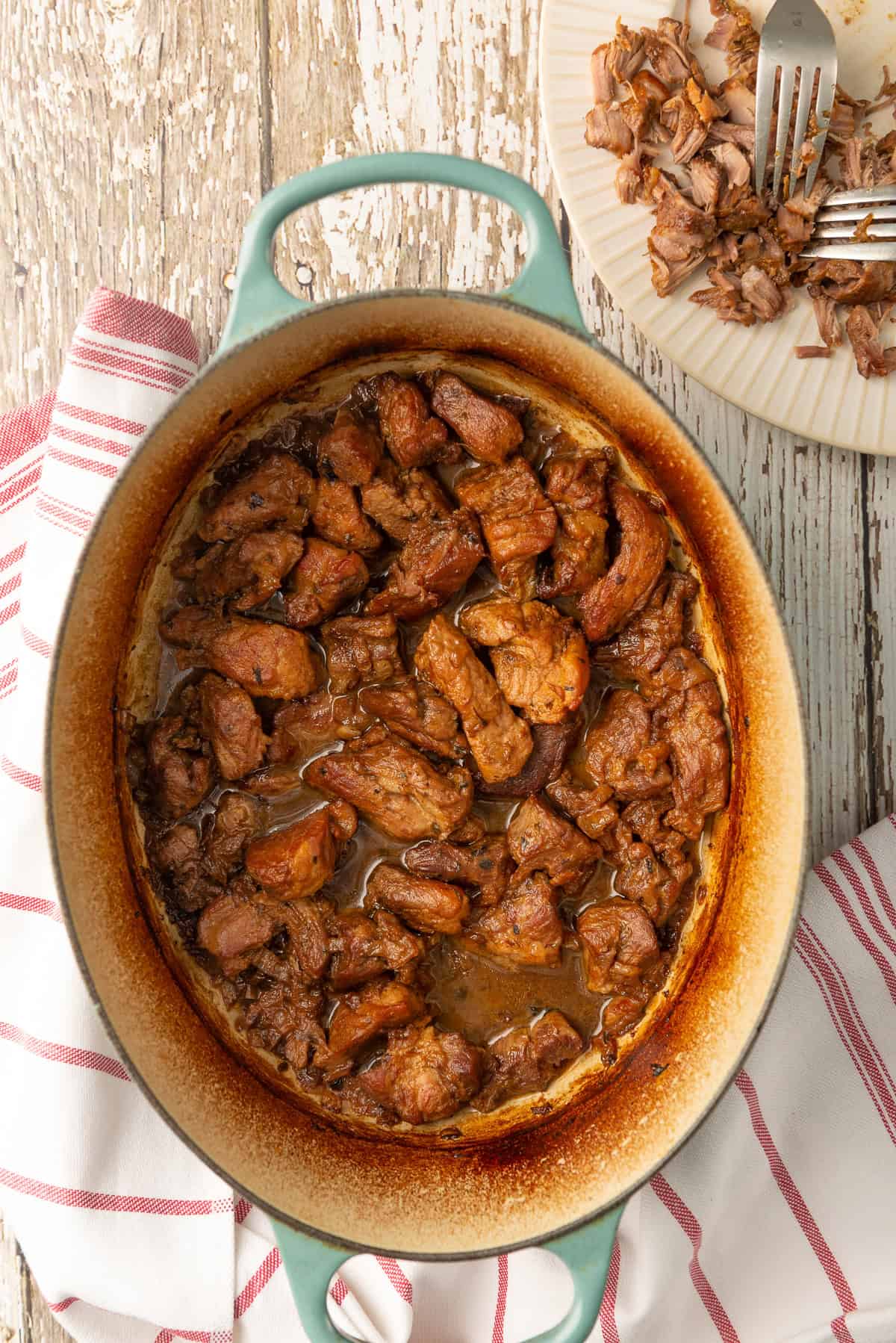 Braised pork cooked until tender in a Dutch oven with juices surrounding the meat.