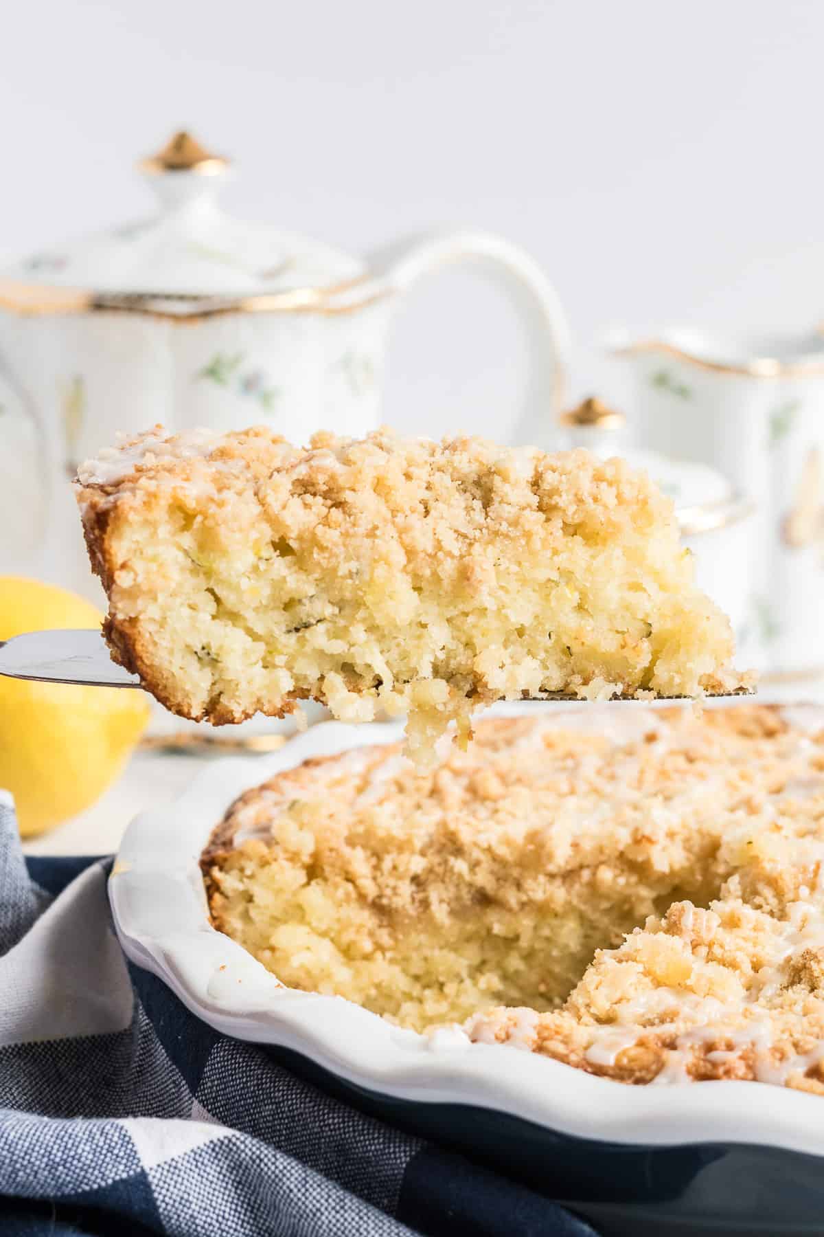 A spatula lifts a slice of lemon zucchini coffee cake.