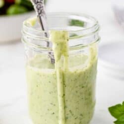 Basil Buttermilk Dressing in a mason jar with a spoon.