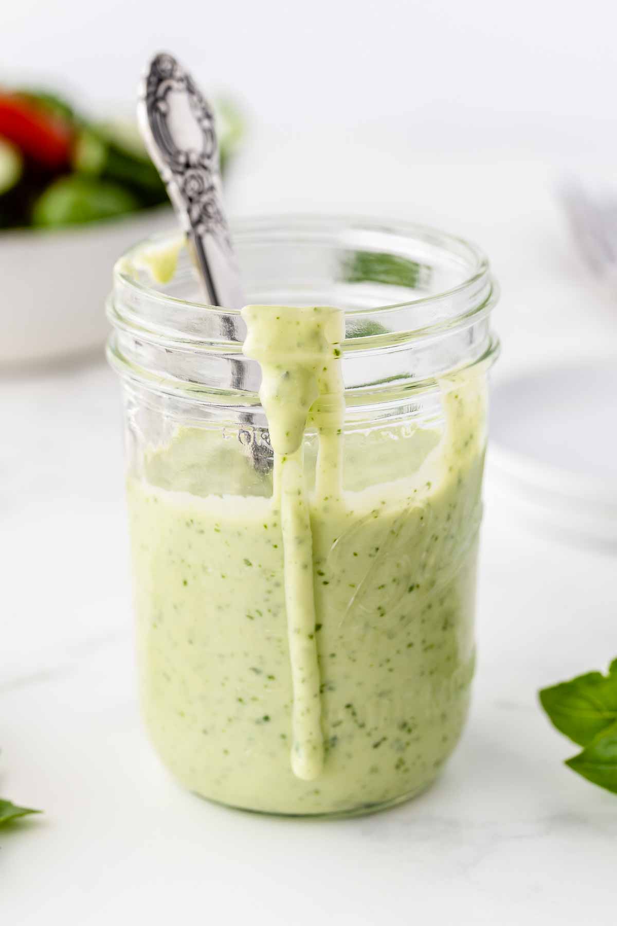 Basil Buttermilk Dressing in a mason jar with a spoon.