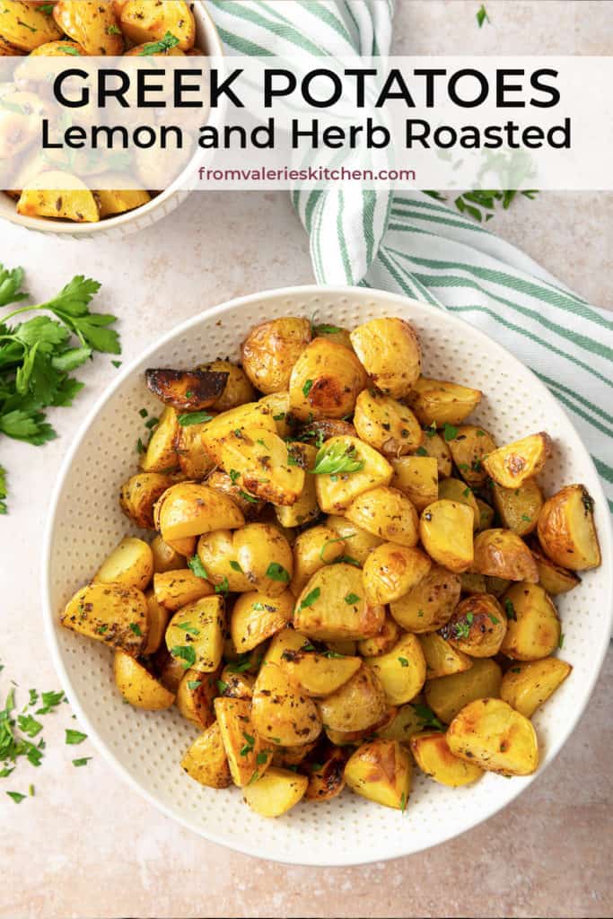 A white serving bowl filled with Lemon and Herb Roasted Greek Potatoes with text overlay.