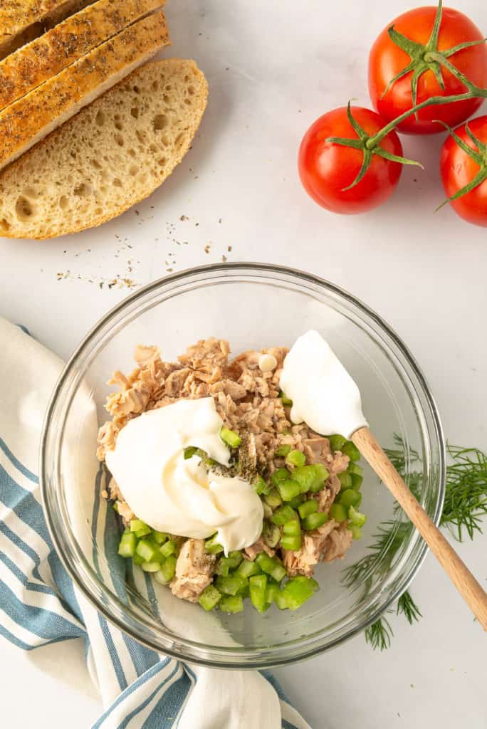 The ingredients in a glass mixing bowl with a white plastic spatula.